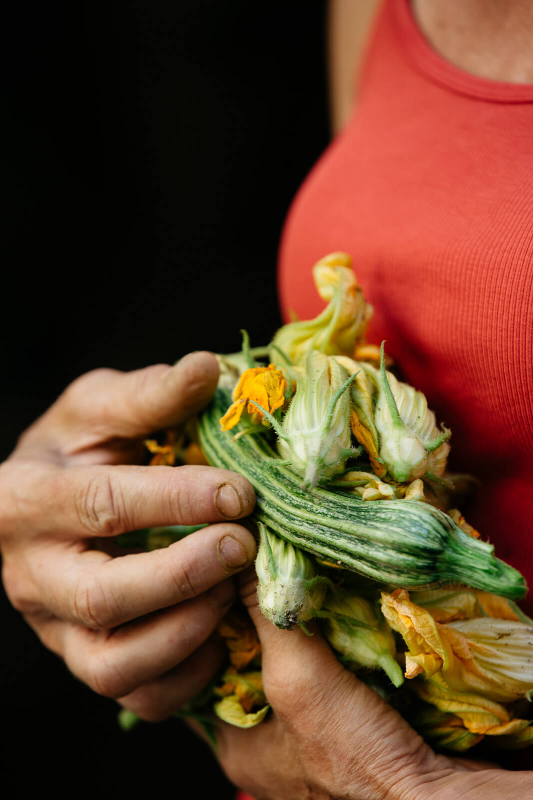 woman holding freshly picked vegetables in arms